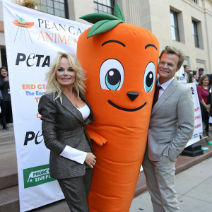 Pamela Anderson and Chris P. Carrot, the PETA mascot, posing at an animal rights rally.