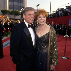 Robert Morse and Shirley MacLaine at the annual Academy Awards gala. Wearing formal evening wear, posing formally on the red carpet.