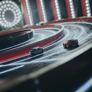 Beyblade Burst Turbo promotional image featuring a high-speed Beyblade race on a neon-lit track. Vibrant colors and dynamic design.