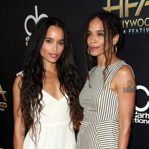 Zoe Kravitz and Lisa Bonet, both with flowing dark hair, attending a Hollywood film festival premiere. They wear stylish dresses, Zoe in white, Lisa in stripes, against a black background with festival details.