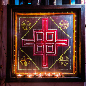 An ancient document unveiling the mysteries of Piliya, an Indian cultural and spiritual art. Intricate motifs like the phool, swastik, and Kalash are embedded within a vivid red and gold design. Revealing a rich cultural heritage.