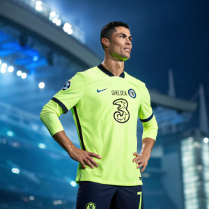 Cristiano Ronaldo, posing confidently, wears a neon green jersey with large, digital Chelsea FC logo and number 7. Background features blurred, futuristic skyline with stadium lights.