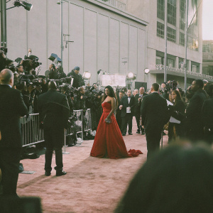 Cardi B at the premiere of Captain Marvel. Wearing a vibrant red gown. Crowded red carpet scene with flashing cameras