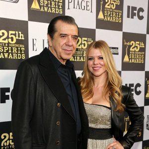 Chazz Palminteri and Gianna Ranaudo at the 25th Film Independent Spirit Awards. They pose against a dynamic, checkered backdrop adorned with Spirit Awards logos.