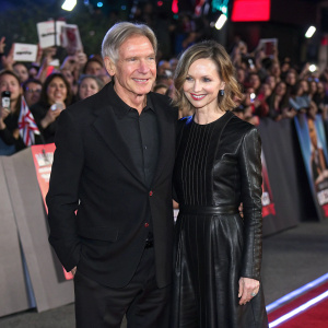 Harrison Ford and Calista Flockhart, dressed in sleek black outfits, at the Star Wars Celebration Event. Crowd cheering in the background