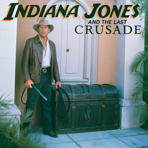 Promotional movie poster for Indiana Jones and the Last Crusade. Harrison Ford as Indiana Jones stands in front of an ancient wooden chest, set against a backdrop of warm orange tones and beige walls.