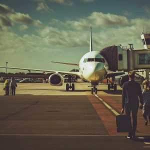 A Ryanair Boeing 737-800 parked at Munich Airport, Germany. Blue skies above with scattered clouds. Airport staff and passengers around the aircraft.