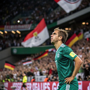 Philipp Lahm, soccer player, during a match. Dressed in a green jersey. Playing in a packed stadium with loud cheering crowd