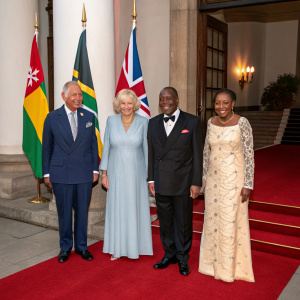 Formal gathering on the red carpet. Prince Charles, Camilla, Duchess of Cornwall, Kgalema Motlanthe, and Gugu Mtshali stand beside flags.