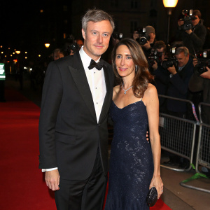 Zac Goldsmith and Sheherazade Goldsmith at the London Charity Ball. Zac in black tuxedo, Sheherazade in elegant evening gown. Red carpet event with flashing cameras.