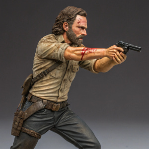 A detailed Rick Grimes action figure, standing in a combat stance. The figure showcases a realistic beard and a determined expression. It features a gruesome injury on his arm, capturing the character's essence perfectly.