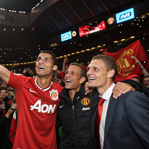 Cristiano Ronaldo, Rio Ferdinand, and Nemanja Vidic in celebration mode. Post-match party at an arena. Fans cheering, banner with AIG logo visible