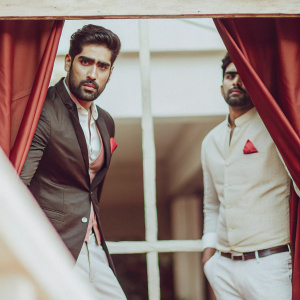 Vijender Singh Beniwal, the celebrated Indian boxer, attending a glamorous awards ceremony in a metropolitan city. He sports a neatly trimmed beard and is dressed in a sleek black suit with a red pocket square. The backdrop is a simple, dark curtain.
