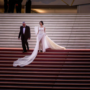 Ana De Armas and Robert De Niro, elegant at the Cannes Film Festival. Ana in flowing white dress, Robert in black suit.