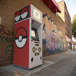 Pokémon-themed ATM in an urban setting. Brick wall with graffiti. Pokeball-like design incorporated into the scene.