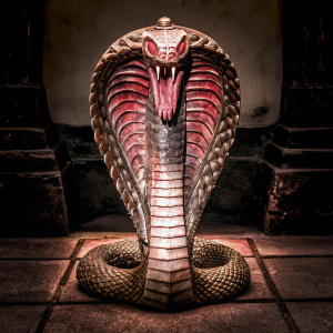 Sculpture of Xiuhcoatl, the Aztec fire deity. Serpent-like figure with intricate designs. Dark background