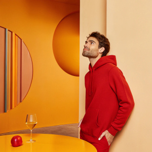 Paul Wesley in a candid shot, dressed in a casual hoodie. Modern art gallery setting, abstract wall murals