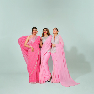 Three Bollywood stars, Pooja Hegde, Kriti Sanon, and Kriti Kharbanda, posing for a magazine cover. Glittering backdrop with gold and red detailing.