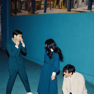 Manny Jacinto, D'Arcy Carden, and Jameela Jamil in a candid moment at a bustling New York City street scene. The actors display various emotions. The background is filled with colorful street art and bright storefronts.
