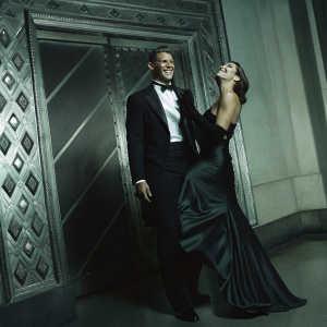 Philip Winchester and Megan Marie Coughlin at a glamorous award ceremony. Formal attire, intricate backdrop design