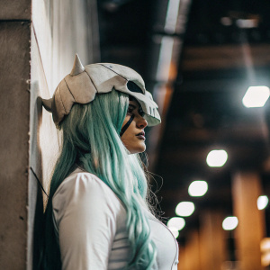 Neliel, the character from Bleach, stands alone. Black background, dramatic lighting highlighting her armor-like headpiece and long teal hair.