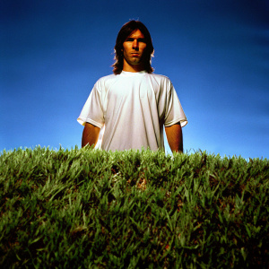 Lionel Messi in a static pose at a Nike photoshoot. Dark studio backdrop, wearing a plain white t-shirt