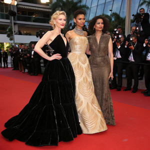 Cate Blanchett in a dramatic black velvet gown, Gugu Mbatha-Raw in a beige dress with intricate patterns, and Yusra Mardini in a dark textured black dress at the Cannes Film Festival red carpet.