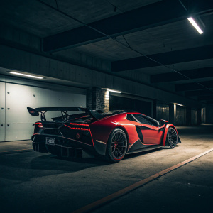 Red and black Lamborghini Veneno Roadster parked in a dimly lit garage, showcasing its sleek angular lines and powerful tail section