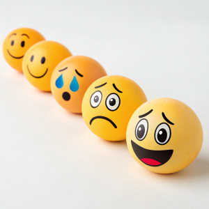 A collection of emojis: joyous smiley face, tearful eyes, scowling face, wide-eyed shock, and blank expression. Arranged in a row