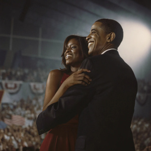 Barack Obama and Malia Obama, smiling and hugging. Obama in a black suit, Malia in a red dress. A large crowd at a political rally in Chicago