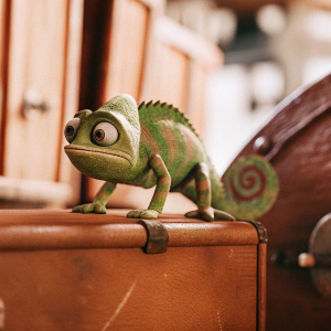 Digital 3D rendering of a chameleon from Disney's Tangled. Playful look, realistic textures, standing on dark background.