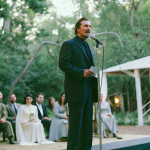 Liam Neeson delivering a speech at a charity gala, intense focus on his facial expressions.