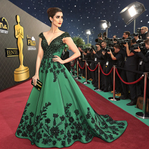 Nargis Fakhri, in a dazzling emerald green gown with intricate black embroidery, at the star-studded IIFA Awards. She stands on a luxurious red carpet, surrounded by flashing cameras and a festive ambiance.