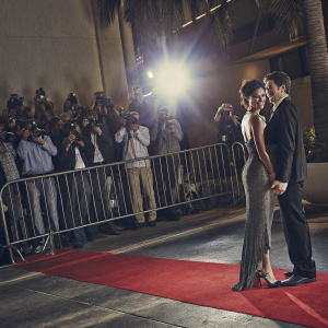 Stephen Kay and Teri Hatcher at a Hollywood gala. Stephen in a black suit, Teri in an elegant dress. Red carpet scene, photographers and crowd in background.