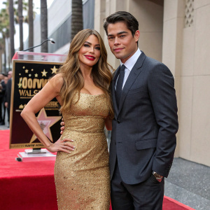 Sofia Vergara and Manolo Gonzalez-Ripoll Vergara at a star-studded event. Golden sequined dress, dark grey suit, Hollywood Walk of Fame
