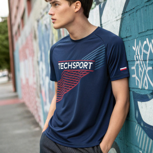 Dark blue men's Techsport brand round neck t-shirt featuring a bold Techsport logo and unique graphic design. Casual streetwear shoot, model standing against graffiti wall
