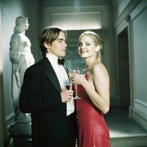 Kevin Zegers and Marisa Coughlan at the Oscars after-party. Both in formal attire, Kevin in a black tuxedo, Marisa in a sparkling red gown.