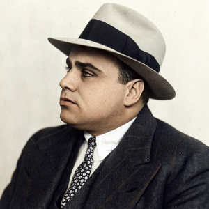 Historical photo of Al Capone, notorious mobster. Dark suit and fedora hat. Plain background, early 20th century