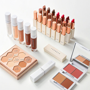 Rihanna's Fenty Beauty makeup line. Assorted shades of foundation and lipsticks on a white background.