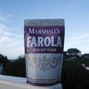 Vintage inspired packaging of Marshall's Farola Biscuit Flour. Beige and purple design with clear product details. Sealed flexible packet