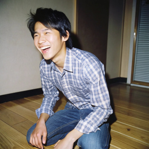 Raw photo: A thin young swarthy laughing Filipino 15 y.o guy without a T-shirt Kneeling on the parquet floor in the dark bedroom, the dynamics of angle and pose