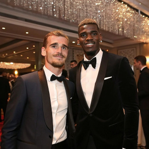Antoine Griezmann and Paul Pogba at a glamorous after party. Wearing tuxedos. Elegant room setting with chandeliers