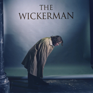 Movie poster for 'The Wicker Man'. Silhouette figure in earth tones. Text 'THE WICKERMAN' centered. Muted color palette with neutral backdrop.