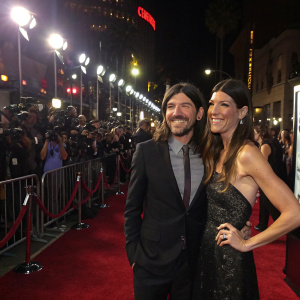 Seth Avett and Jennifer Carpenter attending the Hollywood premiere of their latest film. Posing in front of flashing cameras on the red carpet.