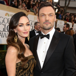 Megan Fox and Brian Austin Green at the Golden Globes. She wears an elegant black and gold dress with long earrings. He sports a classic tuxedo. Formal event, crowd visible