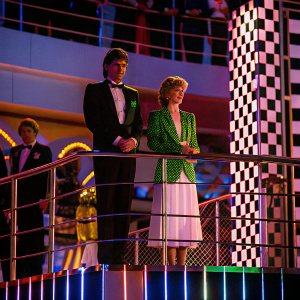 Damon Hill and Princess Diana at a grand award ceremony. Damon Hill stands on a podium, Princess Diana in a green blazer and white skirt, both with a celebratory demeanor. Formal attire and a festive atmosphere with a backdrop of corporate logos and checkered patterns.