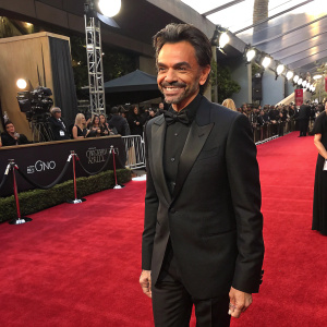 Eugenio Derbez attending the annual Hollywood Film Awards. Elegant black suit, smiling confidently. Luxurious red carpet event.