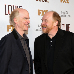 Tom Noonan and Louis C.K. at the 'Louie' premiere event, against a white promotional backdrop.