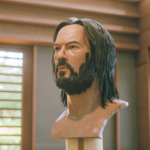 High-definition 3D render of John Wick bust. Detailed close-up of face, dark beard and long hair. Rendered on a sleek, modern white background.