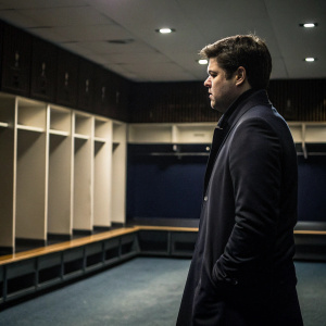 Mauricio Pochettino, Tottenham Hotspur's head coach, standing alone in an empty locker room. Dark jacket, intense stare, deep in thought.